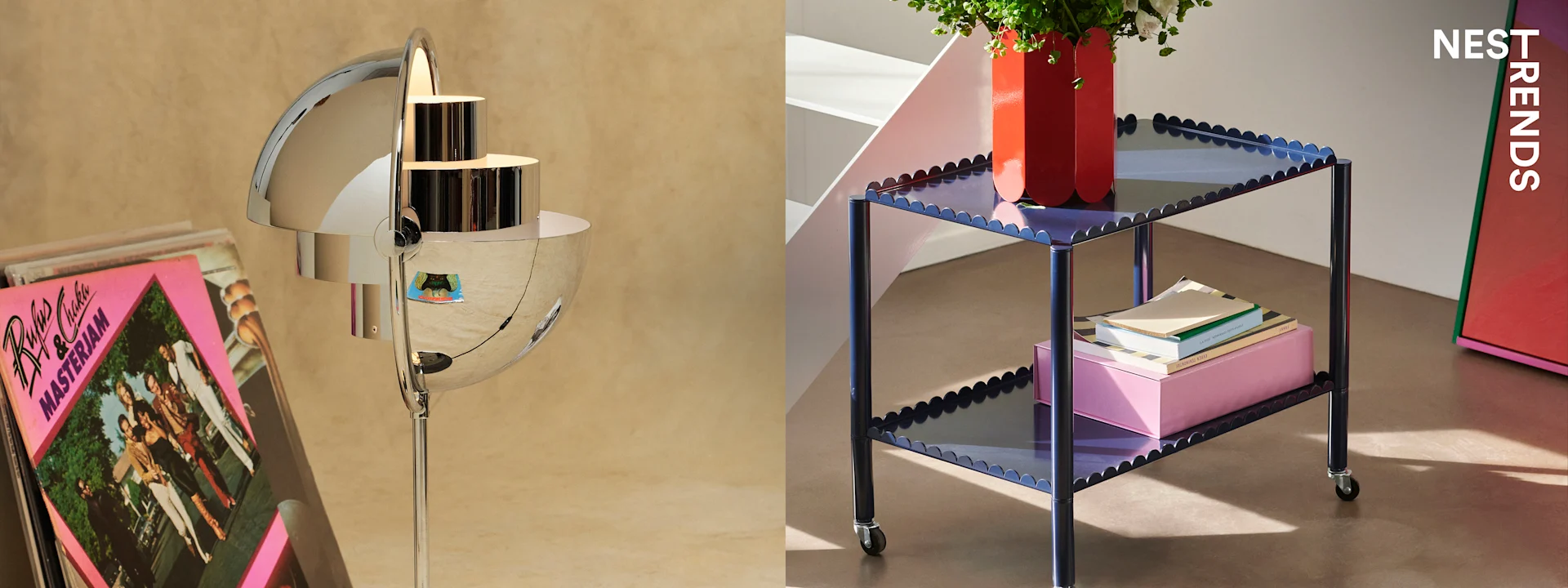 A chrome floor lamp with stacked vinyl records on the left, and a blue scalloped side table with a red vase and books on the right.