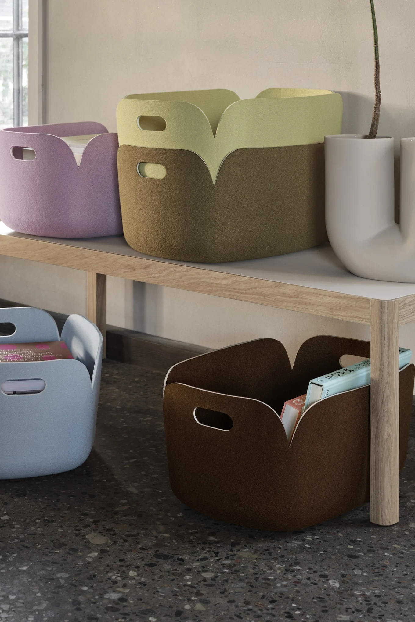 Colorful felt storage baskets on a wooden shelf and floor, holding books and papers.