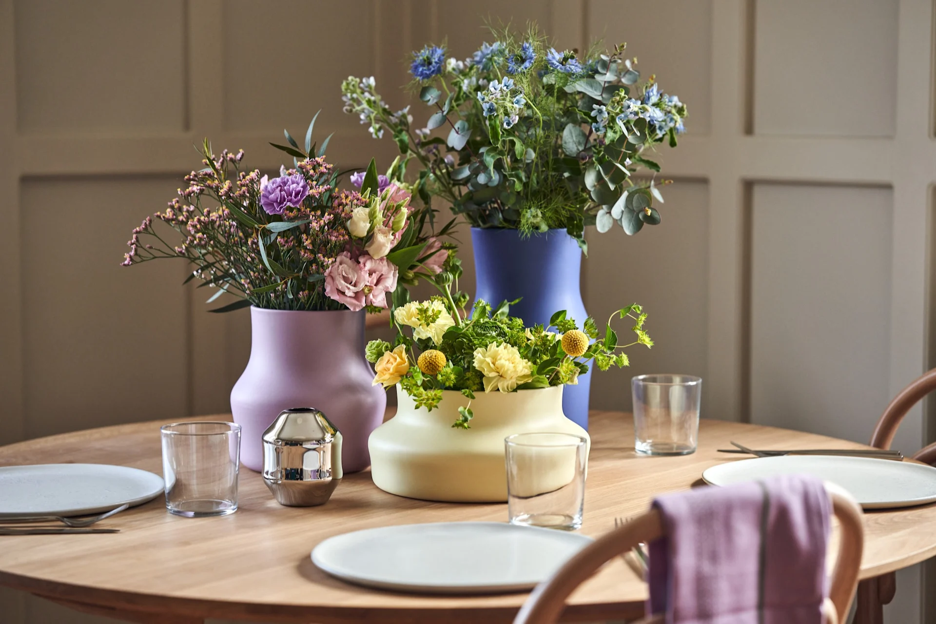 Here you see the colourful ceramic vases from the new extension to the Dorotea collection. They are on a table setting with matching colourful bouquets.