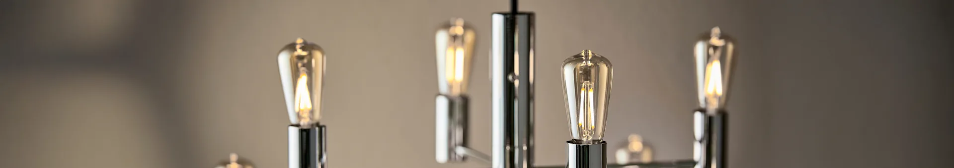 Close-up of a modern chandelier with several illuminated Edison-style LED light bulbs.
